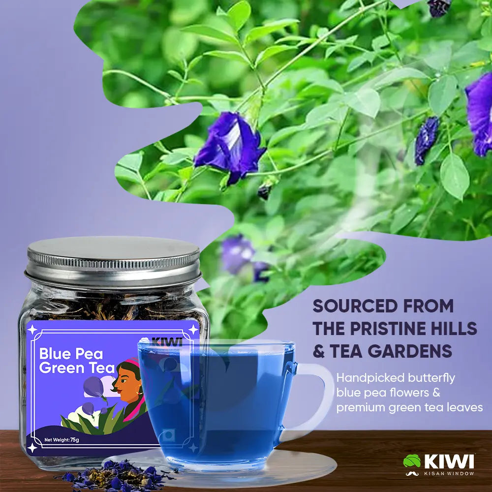A clear glass mug filled with vibrant blue pea green tea, a sprig of mint, and a slice of lime.